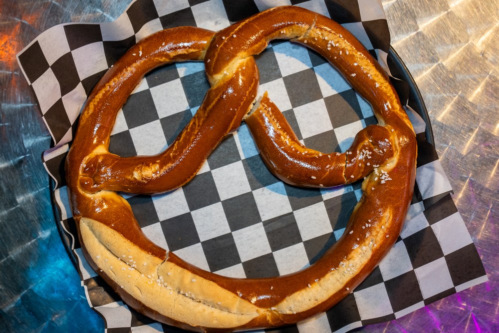 Warm soft pretzel served on a tray at Kava & Company